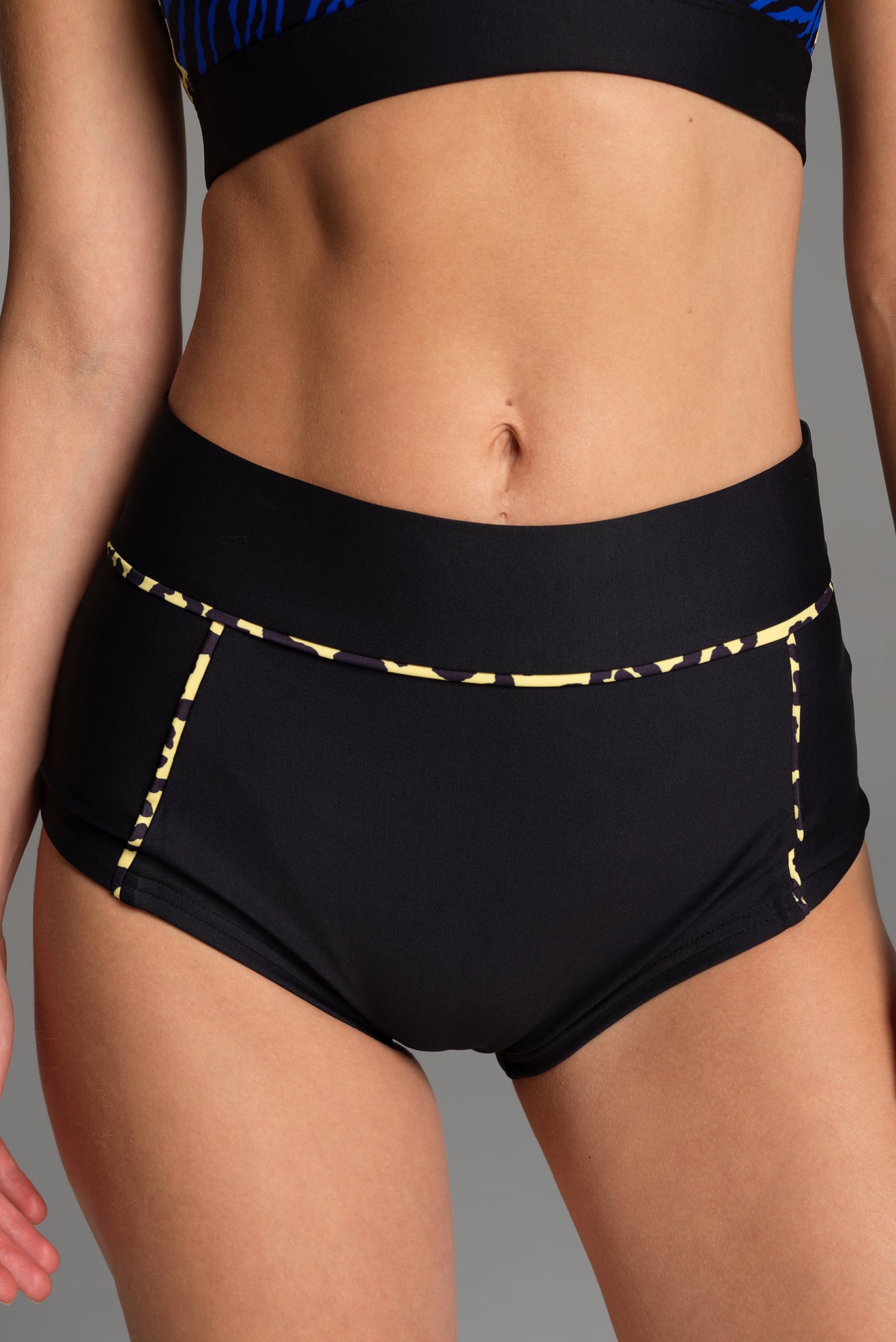 Front image of the X Trainer Sports Short in Black. With a hint of yellow & black animal print, this design draws in the eye to create a shapely effect.
